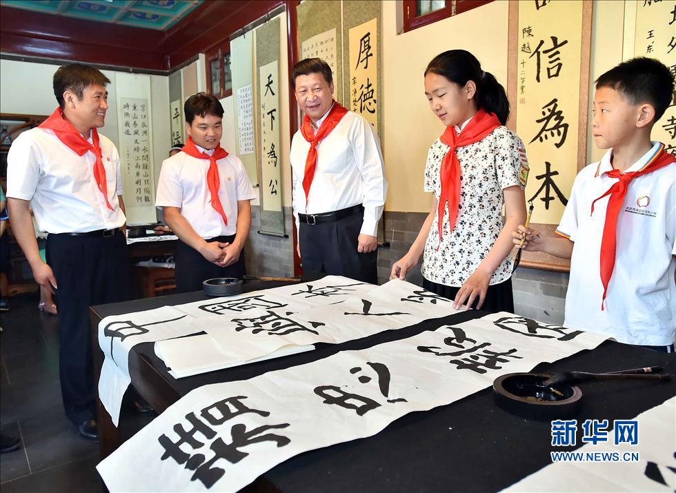 習近平觀看學生書寫的毛筆字。
